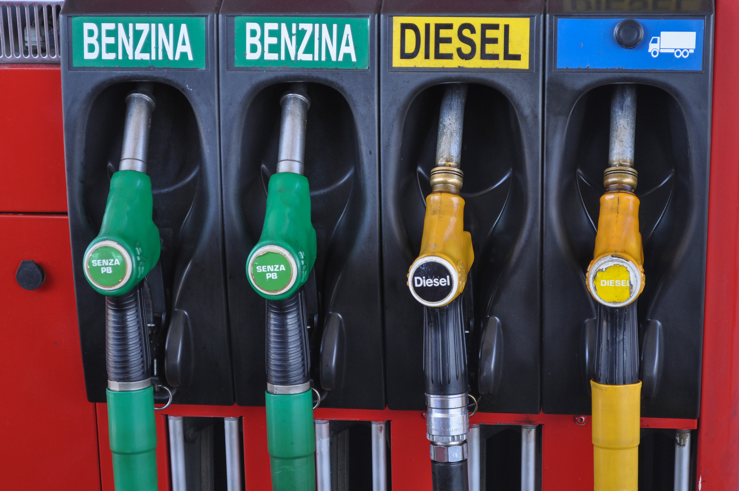 Pistole carburante in primo piano Quattro pistole di rifornimento carburante presso una pompa di benzina