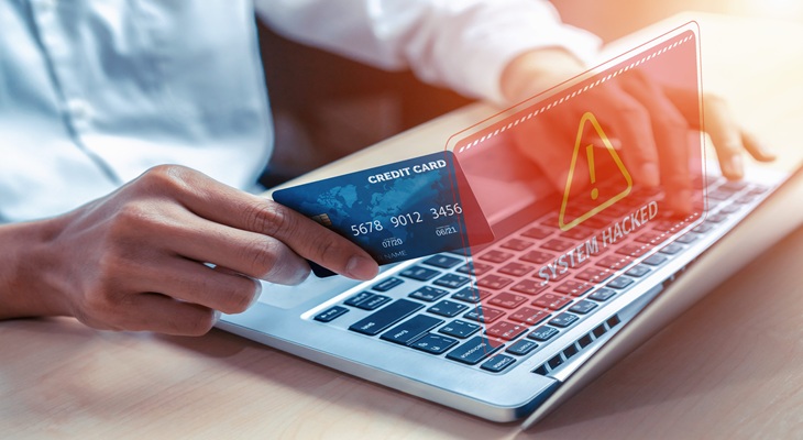 Frodi bancarie e truffe digitali Carta di pagamento e computer, immagine simbolica di frodi bancarie e truffe digitali